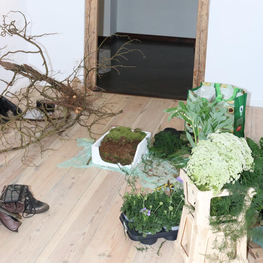Behind-the-scenes preparation shot with raw branches, moss, and fresh greenery for the Daydreaming installation