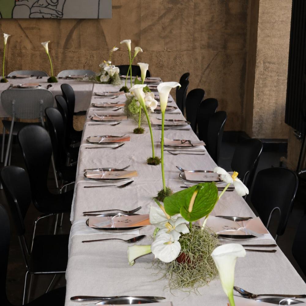 Long reception table set with white calla lily centerpieces on moss bases